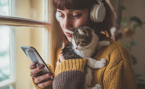 Person holding their cat and phone.