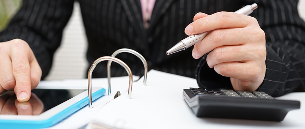 a person holding a writing pen calculating finances